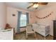 Bedroom with hardwood floors, rocking chair, and baby crib at 470 Waterford Dr, Zionsville, IN 46077