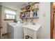 This laundry room features a utility sink, washer, dryer, and open shelving at 470 Waterford Dr, Zionsville, IN 46077