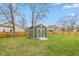 Backyard view of the shed, green lawn and full privacy fence at 470 Waterford Dr, Zionsville, IN 46077