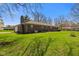 Spacious backyard featuring mature trees, lush green grass, and the home's exterior at 5132 W Blue Bell Dr, New Palestine, IN 46163