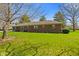 Backyard features a lush green lawn, mature trees and a brick ranch style home at 5132 W Blue Bell Dr, New Palestine, IN 46163