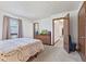 Cozy bedroom with a decorative quilt, a dresser with a TV, and neutral carpeting creating a serene retreat at 5132 W Blue Bell Dr, New Palestine, IN 46163