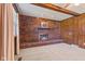 Close-up of a brick fireplace with a mantel, set against wood paneled walls at 5132 W Blue Bell Dr, New Palestine, IN 46163
