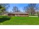 Inviting single-story brick home featuring mature trees and a well-maintained lawn at 5132 W Blue Bell Dr, New Palestine, IN 46163