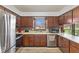 Functional kitchen with wood cabinets, stainless steel appliances, and a view of the outdoors at 5132 W Blue Bell Dr, New Palestine, IN 46163