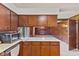 Bright kitchen with wood cabinets looking into Gathering room, with bar for informal meals at 5132 W Blue Bell Dr, New Palestine, IN 46163