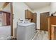 Bright laundry room with white washer and dryer and wood cabinets, offers functionality and convenience at 5132 W Blue Bell Dr, New Palestine, IN 46163