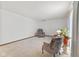 Bright living room featuring neutral carpet, comfortable seating, and soft, filtered natural light at 5132 W Blue Bell Dr, New Palestine, IN 46163