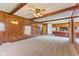 Spacious Gathering room featuring wood paneled walls and a view into a modern kitchen at 5132 W Blue Bell Dr, New Palestine, IN 46163