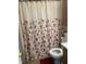 Cozy bathroom featuring a floral shower curtain, tile flooring, and standard toilet fixture at 5338 Traditions Dr, Indianapolis, IN 46235