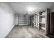A garage is shown with a white door, storage shelves on the back wall, and a concrete floor that can accommodate parking at 562 Monte Vista Dr, Greenwood, IN 46143