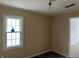 Bright bedroom with a large window, neutral walls, and dark stained floors, offering a blank canvas at 5810 Greenfield Ave, Indianapolis, IN 46219