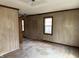 Spacious living room featuring paneling, hardwood floors and three windows offering plenty of natural light at 5810 Greenfield Ave, Indianapolis, IN 46219