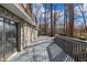 Spacious wooden back deck with stone siding and a view of the surrounding trees at 5917 Camelback Ct, Indianapolis, IN 46250