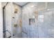 Luxurious shower showcasing blue marble tiling, gold fixtures, glass door, and a convenient shower niche at 5917 Camelback Ct, Indianapolis, IN 46250