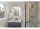 Bathroom with illuminated mirror, grey vanity, and tiled shower with glass doors at 5917 Camelback Ct, Indianapolis, IN 46250