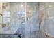 Luxurious shower showcasing blue marble tiling, gold fixtures, glass door, and a convenient shower niche at 5917 Camelback Ct, Indianapolis, IN 46250