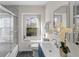 Bathroom showcasing a vanity, tub/shower with elegant tile, and a window at 5917 Camelback Ct, Indianapolis, IN 46250