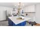 Bright kitchen with white cabinets, stainless steel appliances, large island, and stylish gold chandelier at 5917 Camelback Ct, Indianapolis, IN 46250