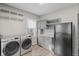 Bright laundry area features new washer/dryer, storage cabinets, and a black refrigerator at 601 Wallace Ave, Indianapolis, IN 46201