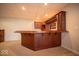 Basement bar area with wood cabinetry, mirrored backsplash, and ample counter space for entertaining guests at 6013 Yellow Birch Ct, Avon, IN 46123