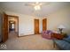 Bedroom featuring carpet, ceiling fan, a pink chair, and a view to another bedroom at 6013 Yellow Birch Ct, Avon, IN 46123
