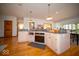 Bright eat-in kitchen features wooden floors, light cabinetry, granite counters and modern stainless steel appliances at 6013 Yellow Birch Ct, Avon, IN 46123