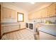 Laundry room with white appliances, white tile floors, and light wood cabinets at 6013 Yellow Birch Ct, Avon, IN 46123