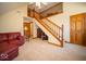Living room area featuring a staircase, a couch, and entry to other rooms at 6013 Yellow Birch Ct, Avon, IN 46123