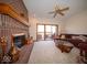 Living room features a red brick fireplace, glass doors to the deck, and a comfortable sofa at 6013 Yellow Birch Ct, Avon, IN 46123