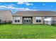 This backyard features a well-maintained lawn, a fenced perimeter, and a covered patio for outdoor enjoyment at 6026 Rockdell Dr, Indianapolis, IN 46237