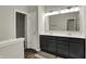 Bathroom with double sink vanity, framed mirror, and wood-look flooring at 6026 Rockdell Dr, Indianapolis, IN 46237