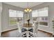Eat-in kitchen features a round table with access to windows, chandelier, and neutral colored walls at 6026 Rockdell Dr, Indianapolis, IN 46237