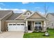 Charming single-Gathering home boasts manicured lawn, covered porch, and attached two-car garage at 6026 Rockdell Dr, Indianapolis, IN 46237