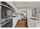 Modern kitchen with stainless steel appliances, island with a sink, dark wood floors, and white cabinetry at 6026 Rockdell Dr, Indianapolis, IN 46237