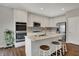 This open kitchen features white cabinets, stainless steel appliances, an island with seating, and dark wood-style flooring at 6026 Rockdell Dr, Indianapolis, IN 46237
