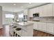 Bright kitchen with white cabinets, modern appliances, and bar-style seating overlooking the dining area at 6026 Rockdell Dr, Indianapolis, IN 46237