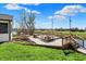 A backyard wooden deck that has a fire pit, overlooking the lush landscaping and pond at 6026 Sally Ann Cir, Indianapolis, IN 46237