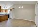 Bright dining room featuring wood-look floors, an elegant chandelier, and a kitchen view at 6026 Sally Ann Cir, Indianapolis, IN 46237