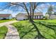 Inviting ranch-style home with lush lawn, long driveway and mature tree casting shadow on the grass at 6026 Sally Ann Cir, Indianapolis, IN 46237