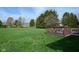 A lush green lawn and mature trees define this backyard space with a small deck in the corner at 6276 Quail Rdg W Dr, Plainfield, IN 46168