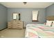 Comfortable bedroom with neutral color palette and dresser with mirror and a colorful quilt on the bed at 6276 Quail Rdg W Dr, Plainfield, IN 46168