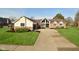 Charming brick home featuring a well-manicured front yard, a long driveway, and an attached garage at 6276 Quail Rdg W Dr, Plainfield, IN 46168