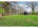 Spacious backyard with a charming shed, surrounded by lush green grass and a sturdy wooden fence at 6481 Michigan Rd, Indianapolis, IN 46268