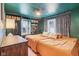 Unique bedroom with dark green trim and wall paint plus built-in shelving and an orange bedspread at 6481 Michigan Rd, Indianapolis, IN 46268