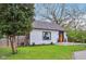 White home with a striking orange door and manicured lawn offers a fresh and inviting curb appeal at 6481 Michigan Rd, Indianapolis, IN 46268
