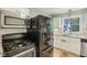 Kitchen with white cabinets, black appliances, and a view of the backyard from the window at 6481 Michigan Rd, Indianapolis, IN 46268