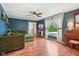 Inviting living room with hardwood floors, a ceiling fan, and a comfortable olive green sofa at 6481 Michigan Rd, Indianapolis, IN 46268