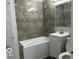 A full bath featuring ceramic tiling, a tub, a vanity, and updated fixtures at 6642 E 47Th St, Indianapolis, IN 46226