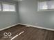 Bedroom featuring two windows, neutral paint, and wood-look flooring at 6642 E 47Th St, Indianapolis, IN 46226